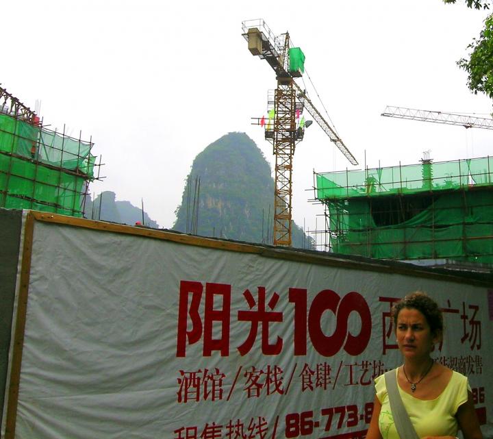 The cranes rise higher than the hills in Yangshuo