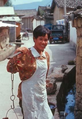 Han Lady fetching water, in Lijiang "new" town. Lijiang, Yunnan, China.