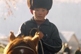 Fur-capped little man in Hemu village, Kenas. Xinjiang province, China.