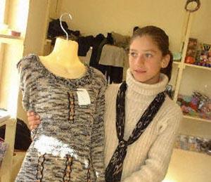 Salesgirl Salma Salat shows one of the outfits for sale at her shop in the Women's Bazaar or Bazaar-e-Zanana in Kabul.