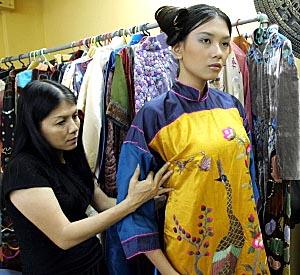 Designer Dang Thi Minh Hanh checks one of her creations with a model at her studio in Ho Chi Minh City, Vietnam.