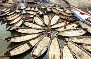 Boatmen make preparations on their vessels before setting out on the Buriganga river in Dhaka.