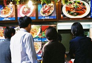 Eating: a very serious business in Singapore. Hungry customers at the Lau Pa Sat Festival Market, Singapore.