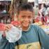 A young boy helps his mother sell souvenirs at an outdoor stand near Angkor Wat