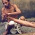 A trained masseurs giving an oil massage at a "ghat" (platform constructed on the river bank) in Varanasi. These masseurs ply their trade at "ghats" in religious places, where people throng to worship in the river, a custom that has been prevalent for centuries. These masseurs, it is believed, can cure all kinds of aches, pains and minor ailments.