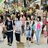 Young tourists stroll on the main shopping street in Naha, Okinawa Prefecture, Japan.