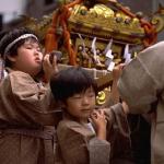 One of Japan's most honored traditions is the Omikoshi Matsuri, the annual Shinto festival. Nearly every Shinto shrine in Japan holds a mikoshi parade, in which a miniature replica of the shrine containing an image of the honored deity is transported through the surrounding streets on the shoulders of local patrons. Depicted here is a youthful version of a traditional mikoshi parade.
