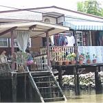 A family enjoys a meal on their canal side house deck