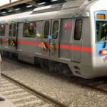 A uniformed platform attendant speaks on his walkie-talkie as a decorated train carrying guests and VIPs prepares to leave the Seelampur station of the Delhi Metro.
