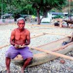 DILI, EAST TIMOR: A fisherman on Meti'aut Beach shows off his horde of old Portuguese money.