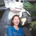 A tourist poses in front of a giant monkey figure at the Lopburi Inn.