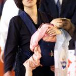 A tired mother carries her sleeping baby amidst a crowd of holidaymakers waiting for a 'shinkansen' bullet train heading home at the Tokyo station.According to a known psychiatrist and director of the Institute for Family Functioning in Tokyo, family roles in Japan remain split along traditional lines with the mothers at home doing the housework on one side and the men as breadwinners on the other, creating a classic family set-up that appeals to fewer and fewer Japanese woman who put off marriage and having children, causing Japan's birthrate to decline.
