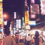 Friends and families enjoy shopping and eating at the night market.
