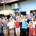 A family of festive Laotians invites us in for some home brew.