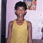 Varanasi, India. The gods, Siva among them, watch over this boy working in a restaurant in Varanasi.
